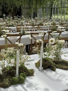 the tables are covered with white flowers and moss