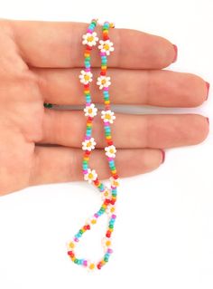 "White seed bead daisy flowers sit amongst bright rainbow coloured seed beads in this stunning Pride necklace! Whether you're supporting pride and the LGBTQ+ community, or you simply love the bright colours....this necklace is sure to bring a smile to someone's face!!  The daisy is also the birth flower for April, making this rainbow necklace a really sweet gift for anyone born in April! Measures approximately 20\" long and fastens with a bolt clasp - you choose the finish, silver/gold plated, s Multicolor Beaded Necklace With Flower Charm For Summer, Multicolor Round Beads Flower Necklace For Summer, Summer Beaded Necklaces With Flower Charm And Round Beads, Multicolor Beaded Necklaces With Flower Charm, Multicolor Flower-shaped Jewelry With Letter Beads, Multicolor Flower-shaped Beaded Necklaces With Tiny Beads, Flower Shaped Beaded Necklaces For Jewelry Making, Rainbow Flower Jewelry With Colorful Beads, Multicolor Flower Shaped Beaded Necklace With Tiny Beads