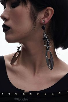 Embrace the perfect fusion of futuristic and punk aesthetics with our Mechanical Punk Metal Earrings / Ear Clips. These striking accessories feature a design composed of multiple spiral metal coils and irregular metal pieces, resembling a spiral galaxy. The bottom of each earring is adorned with a large oval metal plate, adding a bold and edgy element to the overall look. Crafted from premium materials, these earrings ensure durability and a distinctive style statement. Perfect fusion of futuris Edgy Earrings For Concert, Punk Metal Earrings For Concerts, Black Metal Earrings For Alternative Fashion, Punk Style Metal Earrings For Concert, Silver Punk Style Metal Earrings, Punk Style Metal Earrings For Festival, Silver Punk Earrings For Alternative Fashion, Edgy Metal Festival Earrings, Silver Punk Earrings For Concert