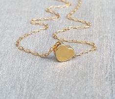 The most dainty gold necklace, such a cute tiny 14K gold-filled heart necklace. Little goldfilled heart on a dainty 14k goldfilled chain. Perfect with layering with other necklaces in my shop! The necklace on the model measures 16 inches. 14k goldfilled little heart pendant measures 6 mm, so simple and sweet! You can wet the necklace and it will not tarnish - Acts like real gold Photo #5 - Sterling Silver necklace (choose your choice from the drop-down menu) ♥ It comes in a beautiful package rea Delicate Gold Heart Charm Necklace, Dainty Charm Necklaces For Mother's Day, Delicate Tiny Charm Necklace For Valentine's Day, Dainty Gold Charm Necklace For Mother's Day, Delicate Gold Heart Necklace For Valentine's Day, Dainty Tiny Heart Necklace For Anniversary, Delicate Yellow Gold Heart Necklace For Everyday, Dainty 14k Gold Charm Necklace For Valentine's Day, Delicate 14k Gold Filled Heart Necklace For Valentine's Day