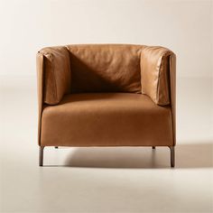 a brown leather chair sitting on top of a white floor