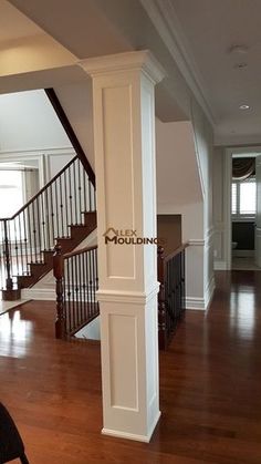 an empty living room with wood floors and white columns