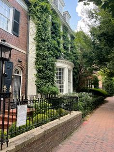 an old brick building with ivy growing on it's walls and gated entrance