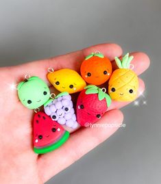 a hand holding a bunch of fruit charms