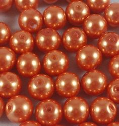 some very pretty orange colored pearls on a white surface