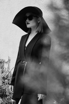 a woman wearing a black hat and sunglasses