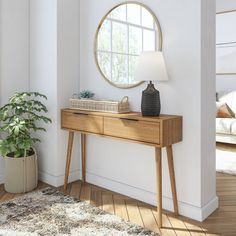 a wooden table with a mirror on it next to a plant and a potted plant