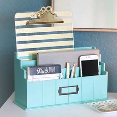 a desk with a cell phone, wallet and other office supplies on top of it