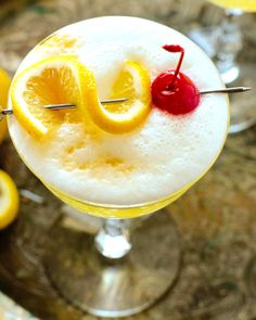 a drink with lemons and cherries on the rim