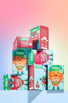 several boxes of fruit juice are stacked on top of each other in front of a multicolored background