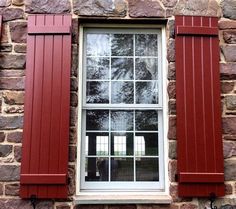 red shutters on the side of a brick building