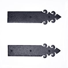 two black metal signs with decorative designs on white background, one pointing to the opposite direction