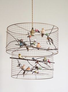 a bird cage hanging from the ceiling with birds on it