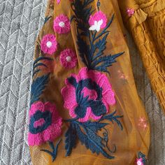 two pieces of fabric with flowers on them sitting on the floor next to each other