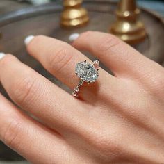 a woman's hand with a diamond ring on it