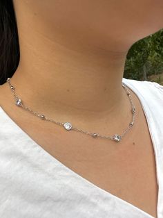 Item Details: This Silver Diamond Station Necklace is resistant to tarnish and adjustable in length, making it comfortable and fitting for all neck sizes. Model in photo is wearing a size 16 inches (40 cm). Materials: cubic zirconia, rhodium plated brass Length (adjustable):     ○ 16 to 18 inches    ○ 40 to 45 cm Care Instructions: To maintain shine and condition,    ○ Keep away from long term water exposure    ○ Remove during bathing, exercise, etc.    ○ Clean and polish with soft cloth * US cu Silver Adjustable Dainty Necklace, Adjustable Silver Dainty Necklace, Silver Clavicle Chain Necklace With Round Pendant, Silver Satellite Chain Necklace With Round Pendant, Silver Cubic Zirconia Jewelry With Delicate Chain, Silver Crystal Chain Necklace With Adjustable Chain, Dainty Adjustable Silver Necklace, Adjustable Silver Clavicle Chain Necklace, Silver Necklace With Satellite Chain