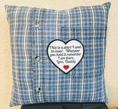 a blue and white plaid pillow with a heart shaped patch on the front that says, this is a shitt i used to wear wherever you hold it remember love today