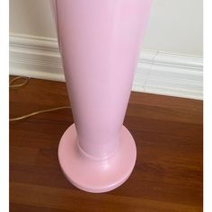 a pink vase sitting on top of a wooden floor