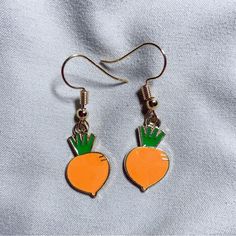 a pair of earrings with carrots on them