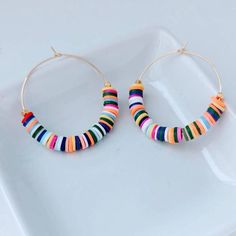 "These are weightless, trendy and so pretty! Gold plated hoops, weightless heishi beads and 2 gold textured beads make these earrings showstoppers! They measure approximately 2\" ." Colorful Dangle Hoop Earrings, Colorful Dangle Hoop Earrings With Ear Wire, Handmade Multicolor 14k Gold Filled Jewelry, Multicolor Tiny Beads 14k Gold Filled Jewelry, 14k Gold Filled Multicolor Tiny Beads Jewelry, Bohemian Heishi Beads Small Hoop Earrings, Bohemian Small Hoop Heishi Bead Earrings, Trendy Colorful Dangle Hoop Earrings, Colorful Small Hoop Earrings For Summer