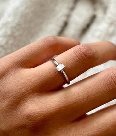 a woman's hand with a diamond ring on it