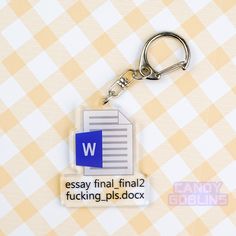 a keychain with the word w on it and a checkered tablecloth background