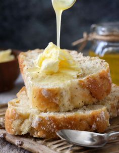 a spoon drizzling butter onto some bread