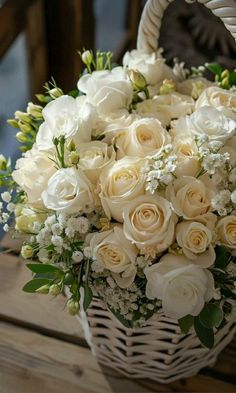 a basket filled with white flowers on top of a wooden table