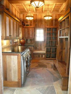 the inside of a house with wood paneling on the walls and floor, including a washer and dryer