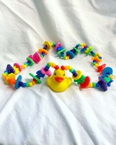 a yellow rubber ducky is surrounded by colorful beads