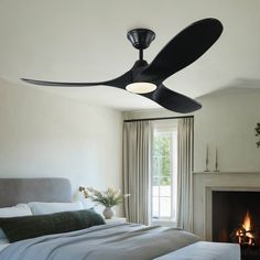 a bedroom with a bed, fireplace and ceiling fan that is black on the ceiling