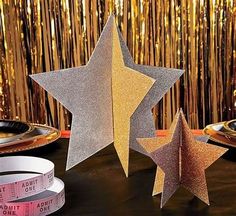 three star shaped paper decorations on a table