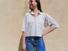 This 80s top has a boxy dolman sleeve fit with a three button collar and faux pocket flaps in a lightweight, breezy fabric with a pretty watercolor pastel plaid. Styled with 1990s handpainted jeans available here: https://www.etsy.com/listing/1702436824/1990s-handpainted-jeans-glitter-purple   55" chest  21" front length 23" back length Modern size Large Sizes as listed on Etsy are my best guess Please always compare to your own measurements for optimal fit Model is 36-29-41 and 5'11" Too Shy! l Vintage Relaxed Fit Cropped Tops, Vintage Cropped Tops With Relaxed Fit, Oversized Blue Top With Placket, Oversized Collared Top For Daywear, Vintage Relaxed Fit Tops For Day Out, Vintage Cropped Top With Buttons, Relaxed Fit Cropped Top With Buttons, Oversized Collared Vintage Blouse, Oversized Retro Button-up Top