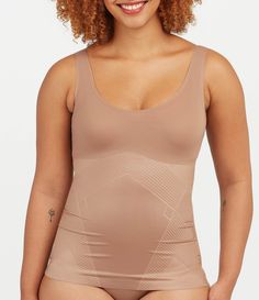 From Spanx&#x2C; this tank features:Lightweight&#x2C; single-layer tummy shaping Flat neckline & armhole stay invisible under clothes Fit-flexible hem construction Body: Nylon/Lycra® elastane; bust: nylon/elastaneMachine wash cold/gentle cycle/do not use fabric softener/only non-chlorine bleach when needed/tumble dry low/do not ironImported. Fitted Sports Shapewear With Built-in Bra, High Stretch Nylon Tank Top With Built-in Bra, Compression Shapewear With Built-in Bra In Elastane, Shapewear Tank Top With Built-in Bra And Wide Straps, High Stretch Seamless Shapewear Tops, Seamless Compression Sleeveless Top, Smoothing Stretch Elastane Tops, Stretch Shapewear Tops, Fitted Seamless Shapewear Tops