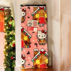 a hello kitty towel hanging on the wall next to a christmas tree and other decorations