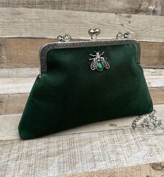 Stunning, handmade, green velvet purse bag with bee detail. The lining is made with a beautiful cotton fabric. Use it as a classic clutch or attach the shoulder strap to wear over your shoulder or as a crossbody - Silver colour Chain strap (detachable) - Silver colour Metal Top handle ( not detachable) - H:19cm x W:29cm x D:4cm approximately - Metal clasp: H:6.5cm x W:20cm - Top handle: H:8.5cm - Agate stone detail (The markings on the stone may be slightly different) The pattern of the lining i Velvet Pouch Bag For Gifts, Velvet Pouch Bag As Gift, Velvet Pouch Bag For Gift, Green Shoulder Evening Bag As Gift, Green Clutch Bag As Gift, Green Clutch Bag For Gift, Handmade Green Evening Bag, Handmade Velvet Bags For Gifts, Handmade Velvet Rectangular Bags