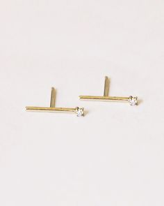 A 14k yellow gold stick earring with a small white diamond on the end. GJENMI is handmade in Los Angeles from conflict-free diamonds and ethically-sourced stones. –1.5mm white diamond Minimalist White Gold Diamond Earrings With Single Diamond, Minimalist Diamond Earrings With Single Diamond, Minimalist White Diamond Earrings With Single Diamond, Minimalist White Diamond Earrings With Single Stone, Minimalist Diamond Earrings For Anniversary, Minimalist 14k Gold Single Diamond Earrings, Minimalist White Diamond Earrings For Everyday, Minimalist Single Diamond Earring, Minimalist White Diamond Earrings