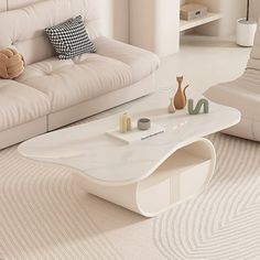 a living room with white couches and a coffee table in the middle on carpeted flooring