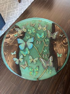 a glass table with butterflies on it and a bear in the middle, sitting on a wood floor