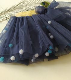 Material eurofatin (2 layers) with felt pompoms. Stretch satin lining. The color is dark blue. Length 25 cm, waist circumference 48-55 cm A wonderful tutu for your little princess for her birthday, as a gift SIZE 1-4 year MATERIAL Tulle, Satin, Textile Pom Poms, Waistband SHIPPING The average processing time is 1-3 business days. Standard shipping time takes about 21-28 days. Express DHL delivery takes 3-6 days, and UPS time frame is 10-12 days (US). CLEANING AND CARE INSTRUCTIONS Turn the item inside out, select a delicate cycle on the washing machine, and make sure the water temperature is cold and the spin is low. Do not bleach! Choose tumble dry low (Delicate/Gentle cycle) or lay the item flat in its natural shape on a drying rack or hang to dry. Do not iron directly on the design! To Pom Pom Tutu, Tulle Skirt Kids, Pom Pom Skirts, Blue Pom Pom, Girls Tulle Skirt, Handmade Tutu, Kids Tutu, Wrinkle Remover