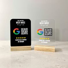 two glass plaques sitting on top of a table next to each other with qr - code printed on them