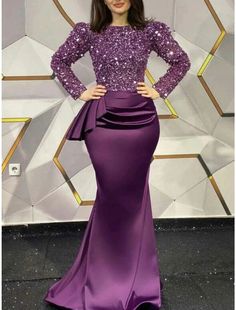 a woman in a purple dress posing for the camera with her hands on her hips