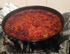 a large black pot filled with food on top of aluminum foil