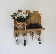 a potted plant on a wooden shelf with keys hanging from it's hooks