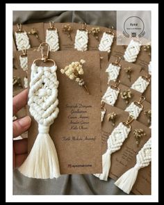 some white tassels are being held by someone's hand and there is a tag