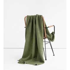 a green blanket sitting on top of a chair