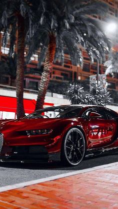 a red bugatti is parked on the side of the road in front of some palm trees