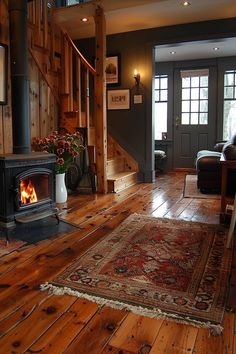 a living room filled with furniture and a fire place next to a wooden floored staircase