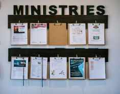 a bulletin board with clipboards attached to it