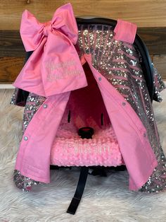 a pink and silver stroller with a bow on it